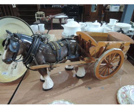 A ceramic horse and treen cart