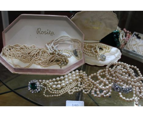 A shelf of pearl necklaces vintage and modern with ornate clasps. 