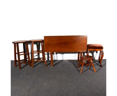 Two fruitwood and beech stools, with an oval seat, height 61cm; a mahogany drop-leaf occasional table,; fruitwood stool.