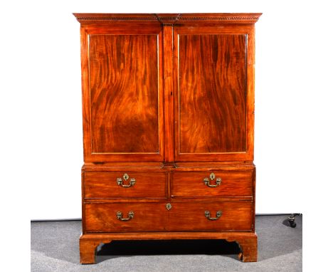 A George III mahogany linen press, of small proportions, blind fretwork frieze, two panelled doors to the upper section, adap