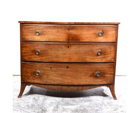 A George IV mahogany bowfront chest of drawers, cross-banding and stringing, fitted with three graduating drawers, splayed br