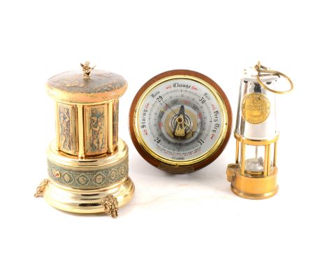 A circular modern aneroid barometer, 20cm diameter, musical cigarette dispenser by Reuge, embossed leather decoration, three 
