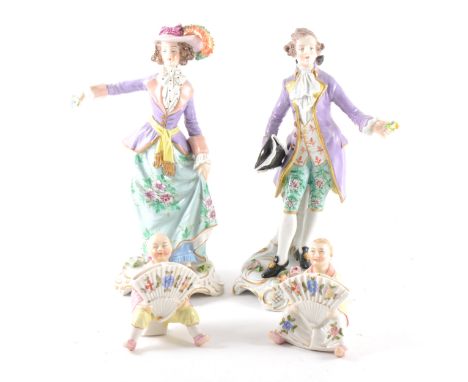 A pair of Sitzendorf figures, modelled as a lady and gentleman, 22cm; and a pair of continental figural menu stands, modelled