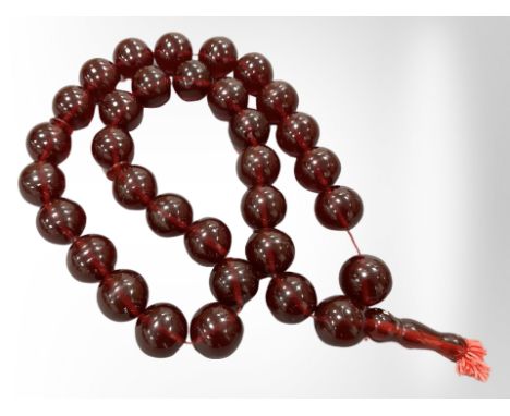 An impressive large cherry amber necklace with thirty three large spherical beads, each approximately 3 cm diameter, gross we