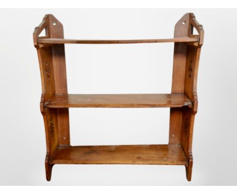 A Victorian carved walnut three tier wall shelf, width 68 cm 