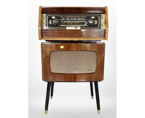 A vintage walnut-cased AGD Valve radio with a Dynatron speaker on tapered legs.