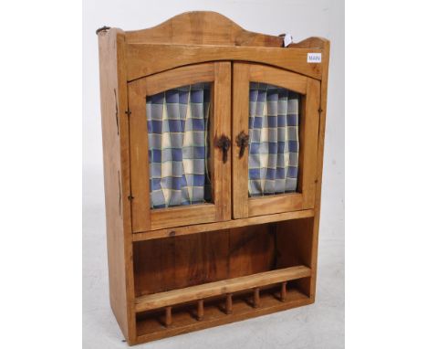 20th century wooden pine wall hanging kitchen cabinet. Featuring two glazed cabinet doors with blue plaid fabric curtains and
