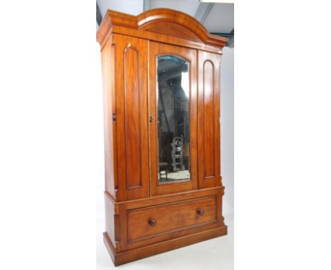 Victorian 19th century mahogany single wardrobe. Featuring a dome top pelmet over a mirrored door upright wardrobe raised on 