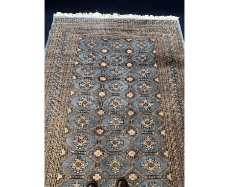 A Bokhara carpet with repeating gul medallions on a powder blue ground within multiple geometric borders. L.275 W.186cm