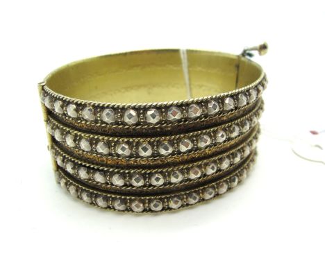 A XIX Century Wide Hinged Bangle, of cut steel appearance gilt hinged to pin clasp, internal diameter 5.7cm.