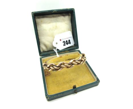 A c.Late XIX / Early XX Century Bangle, of part textured twist design to the front, hinged to snap clasp, indistinctly stampe