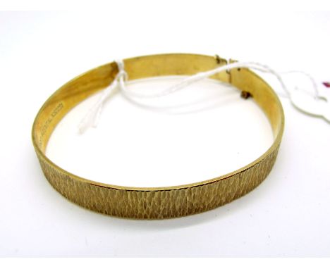 A 9ct Gold Bangle, of textured bark design (15grams). 