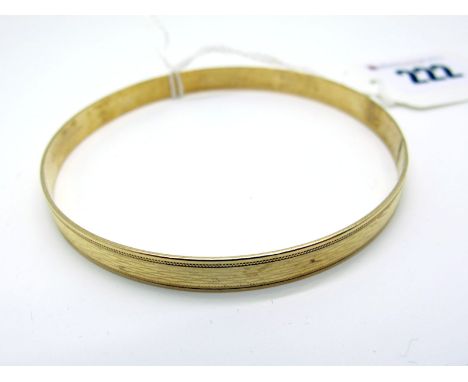 A Modern 9ct Gold Bangle, of engine turned design (10grams). 