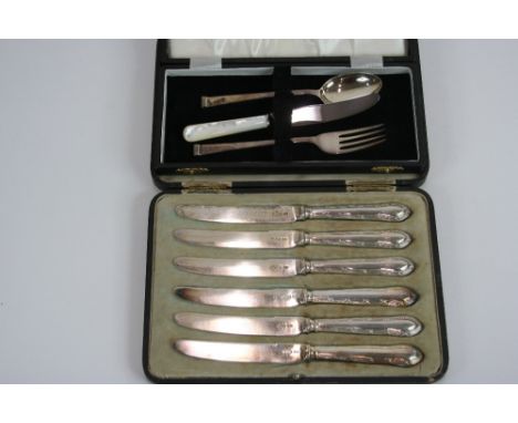 A cased set of six silver bladed fruit knives, by Walker & Hall Sheffield 1921; and a modern cased silver christening spoon a