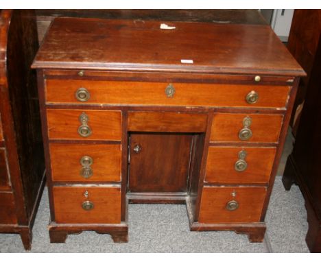 A 19th Century mahogany kneehole desk, fitted brushing slide above a long drawer, central frieze drawer and cupboard, flanked