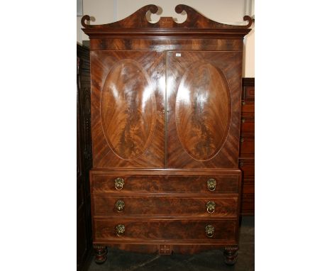 A George III mahogany, rosewood cross-banded and satinwood strung linen press, surmounted by a scroll arch pediment, interior