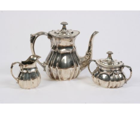 A continental silver three piece teaset, of baluster fluted form with beaded borders, comprising teapot, milk jug, and covere