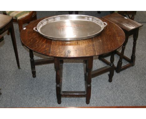 An Antique oak gate leg dining table, the rounded drop leaves raised on turned baluster supports united by stretchers, 110cm 