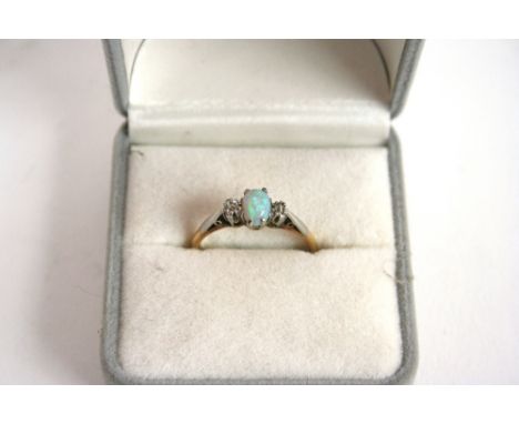 An 18ct gold and platinum ring, set central opal flanked by diamonds