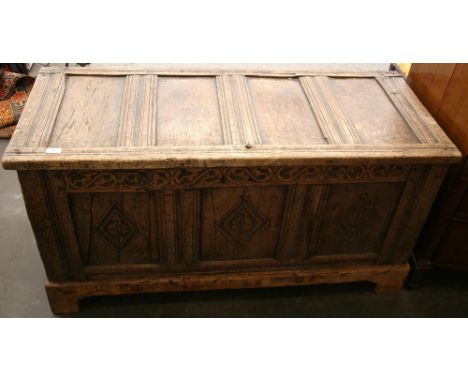 An Antique oak coffer, having plain triple panel lid and lozenge carved front, raised on bracket feet, 127cm