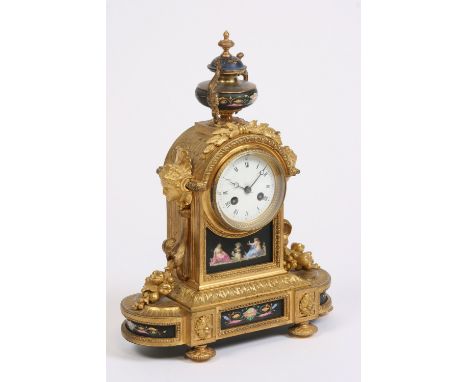 A 19th Century French gilded mantel clock, decorated with Sevres style panels and urn finial, circular white enamel Roman num