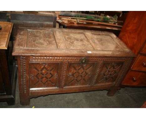 An Antique oak coffer, the triple panel lid opening to reveal a candle box interior with carved front raised on stile end sup