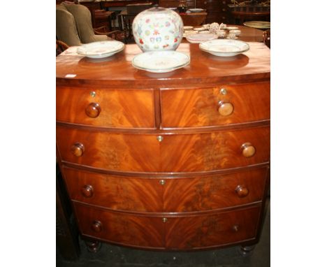 A Victorian mahogany bow fronted chest, of two short and three long graduate drawers, raised on turned supports, cut in two s