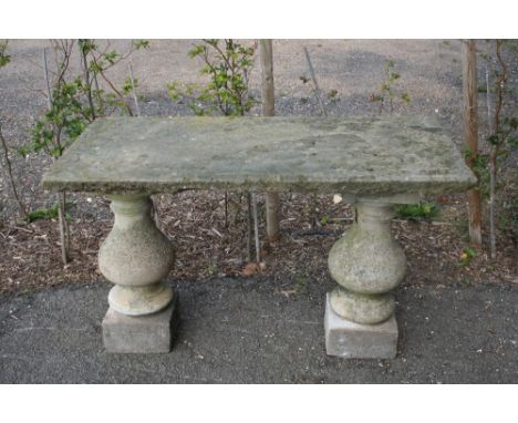An Antique stoneware bench, raised on baluster columns, 121cm wide x 61cm deep x 72cm high