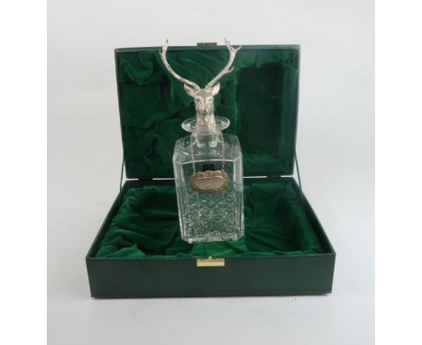 A CASED EDINBURGH CRYSTAL DECANTER of canted square form, the stopper modelled as a stag, with a silver label with moulded sc