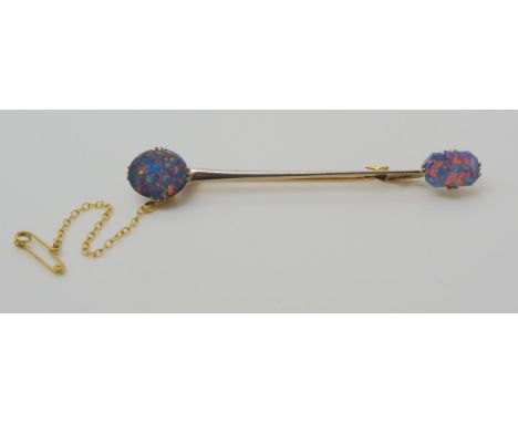 AN OPAL BAR BROOCH the yellow and white metal bar brooch, is set with two lively opal doublets. Brooch stamped both 15ct and 