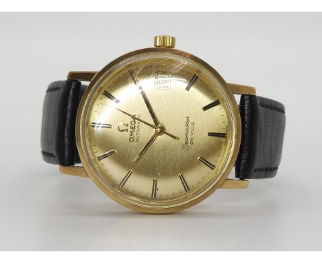 AN OMEGA SEAMASTER DE VILLE AUTOMATIC with yellow metal case, gold coloured dial, hands and baton numerals, with a date apert
