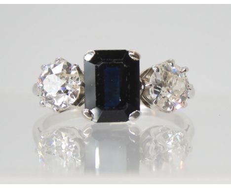 A SAPPHIRE AND DIAMOND THREE STONE RING set throughout in white metal, the two diamonds have an estimated approximate total t