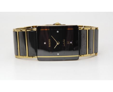 A RADO JUBILE with black diamond set oblong dial with date aperture and gold coloured hands, with a gold coloured stripe that