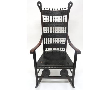 A 19TH CENTURY CONTINENTAL ROCKING CHAIR with carved slated back interspaced with turned bobbins over embossed leather seat f