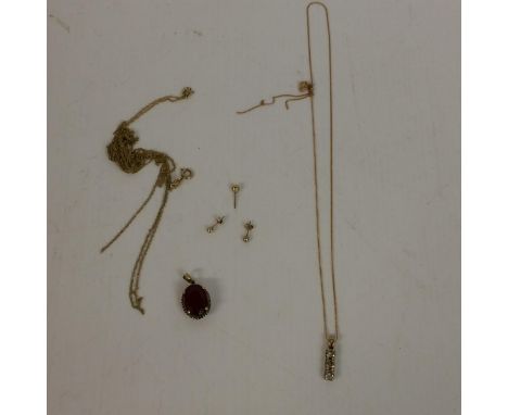 yellow metal chain, studs and a ruby coloured pendant 