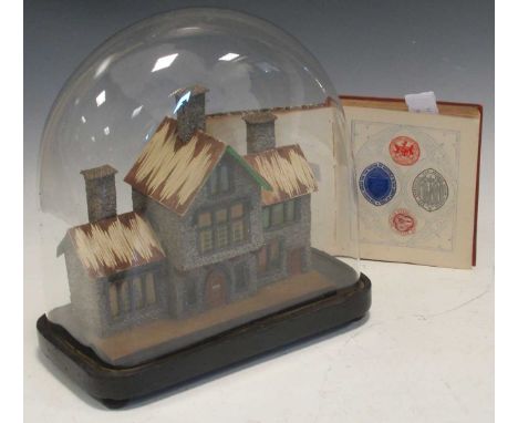 A late Victorian model villa under a glass dome on stand and a small album of crests (dome approx 30cm high)A few small marks