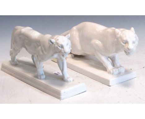A Berlin porcelain white glazed model of a tiger and another white glazed model of a tiger 19 x 35 x 10cm and 18 x 42 x 13cm 