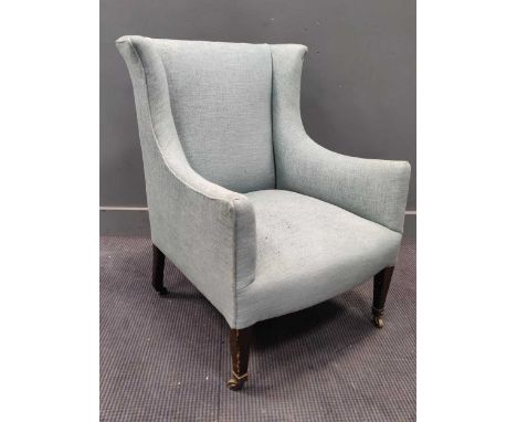 An early 20th century armchair with light blue upholstery raised on tapered front legs and castors, 87 x 65 x 62cm