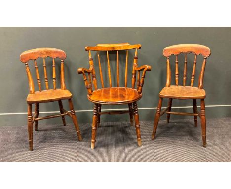 An early 20th century mahogany stick back armchair; together with a pair of elm seated stick back chairs (3)