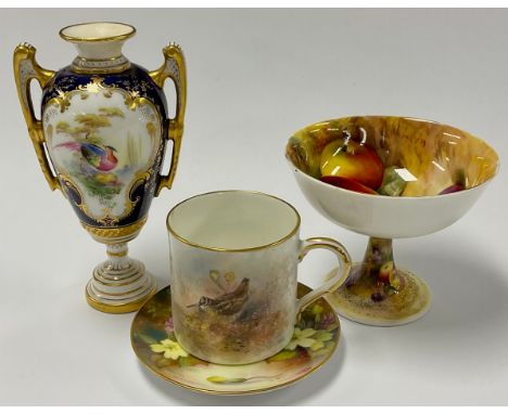 A Royal Worcester two handled pedestal vase, painted with a bird in landscape, within gilt scroll cartouche on cobalt blue gr