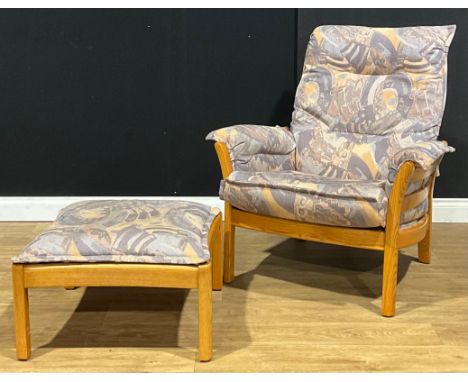 An Ercol Saville easy chair, model 930, 99cm high, 87cm wide, the seat 52cm wide and 50cm deep; a conforming footstool, model