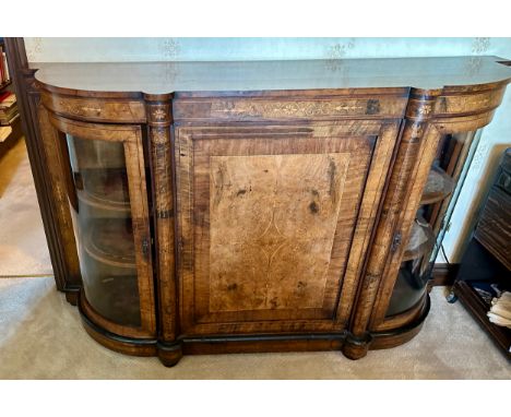 A burr walnut inlaid credenza sideboard with curved glass doors to each side with two shelves. Central shelf with one shelf t