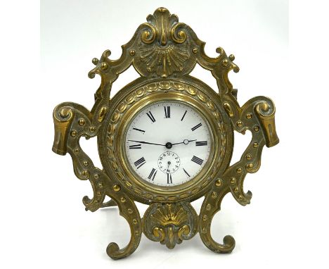 A brass easel mantel clock with ceramic face 8.5cm d and roman numerals.  Movement marked SF and GB to interior casing. Heigh