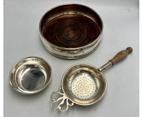 Silver wine coaster London 1985, maker David R Mills together with a silver tea strainer and base by the same maker.