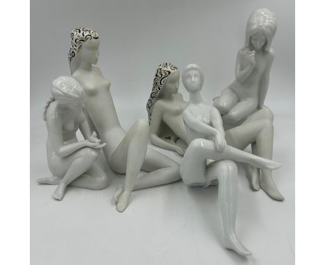 A collection of Royal Dux figurines to include two recumbent bisque figures with black and gold embellishment both designed b