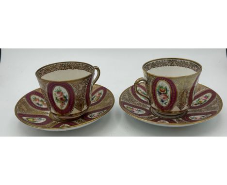 Two early 19th century hand-painted porcelain cups and saucers with raised gilding and floral vignettes, c. 1820. Saucers: 14