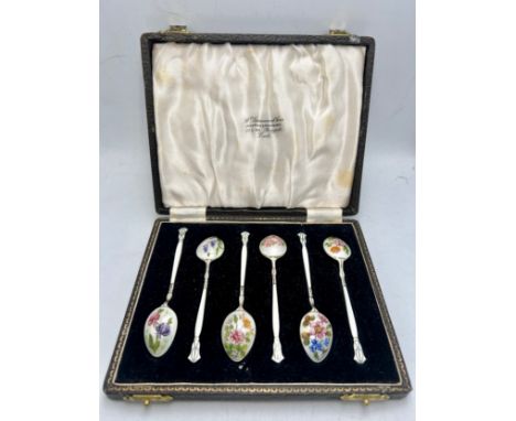Six boxed silver and enamel coffee spoons, each with differing floral decoration. Total weight 55gm. Birmingham 1952, Maker H
