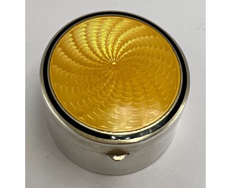 A German .935 silver and enamel circular pot with yellow guilloche enamel to top and gilt interior with mirror to lid. 3.5cm 