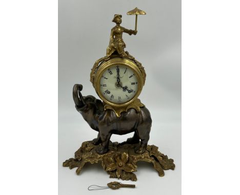 A gilt metal Imperial Mantel Clock by Brevettato of Italy with white enamel dial and roman numerals with a figure holding and