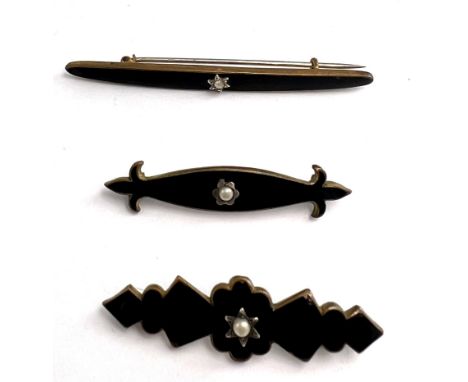 Three Victorian black enamel mourning brooches, each set with a single seed pearl. Length of longest. 6.5cm
